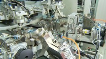 Advanced industrial production line for small parts, robotic arms working