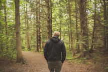 a man walking alone in a forest 