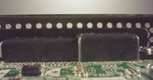 Extreme macro dolly shot of a PCB computer board with capacitors and transistors