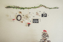frames and ornaments hanging on a wall and a Christmas tree 