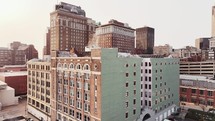 Drone flying up on misc tall buildings in downtown Saint Louis, Missouri on a clear sky morning.