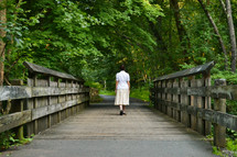 a woman walking across a bridge 