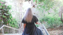 a woman walking down steps in a flowing dress 