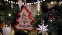 Wooden Merry Christmas ornament on Christmas tree