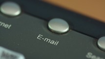 Macro shot of a finger pushing the email button on a keyboard
