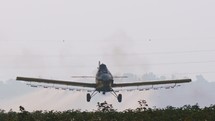 Crop duster spraying chemicals over a cotton field - slow motion