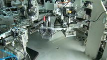 Advanced industrial production line for small parts, robotic arms working