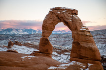 Delicate Arch in Utah taken with snow on it right after sunset.