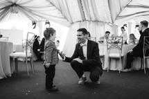 a groom talking to a child at a wedding 