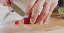 Slow motion of chef knife cutting a strawberry