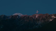 Crucifix on mountain top at moonrise