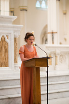Bridesmaid speaking at a podium.