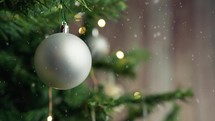 Christmas tree under the snow with silver ball as decoration