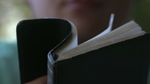 man flipping through the pages of a Bible 