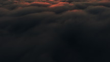 Flying above the clouds at sunrise aerial view