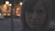 Close up of a sad young woman at night in the city