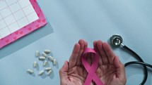 Doctor Puts Pink Ribbon On Table