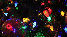 A pan across colorful lights and ornaments on a Christmas tree