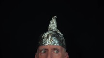 A man who is a conspiracy nut wearing a tinfoil hat