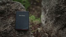 Closed Bible on a rock outside.