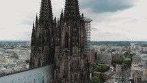 Aerial circling the historical Cologne Cathedral during it's renovation construction in Cologne, Germany.