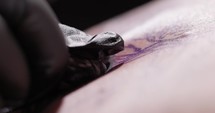 Tattoo Artist Hand In Gloves During Tattooing Procedure. - close up shot