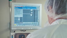 Worker in front of a computer screen in an electronic manufacturing line