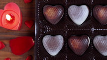 Valentines Day concept heart shaped chocolate with candles on wooden background. Love concept. Dolly shot 4k