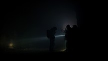 Rescue forces search for survivors inside a dark tunnel using flashlights