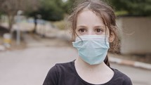 Coronavirus pandemic close up on girl face wearing face mask to avoid contagion