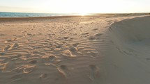 Walking on the soft sand of empty beach near the ocean in Sicily coast