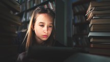 Young student with a tablet in library. High school work. Girl study and doing homework with using tablet computer at library.