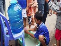 a child washing his hands in clean water 