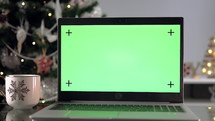 Green screen laptop with coffee by Christmas Tree