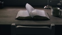 pages turning on a Bible on a desk 