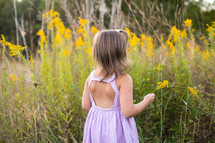 a toddler girl picking flowers 