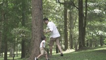 Portrait of Asian Father and Child Love Enjoying Activities at The Park - Playing, Holding Hand, Running in Slow Motion