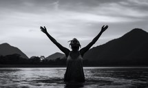 Baptism. Silhouette of a black woman in the water. Black and white.
