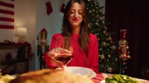 Girl drinking wine and cheering with the table set for thanksgiving