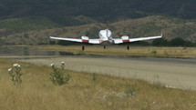 A twin engine airplane landing at a mountain airstrip