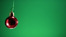 Red Christmas ball on green screen 