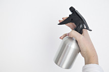 a woman holding a spray bottle 