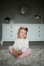 smiling toddler girl on a fur rug 