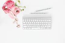 pink flowers, computer keyboard, pencils, and clips 