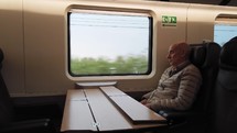 Elderly man is sleeping during travel by train