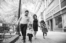 a family walking on a sidewalk 