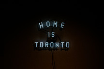 Neon sign saying Home is Toronto