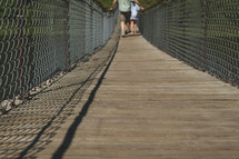 people crossing a footbridge 