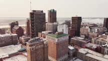 Aerial pan around tall buildings in downtown Saint Louis, Missouri city reveals the Arch on a beautiful clear sky morning.