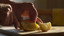 A man cutting slices of fresh lemon
